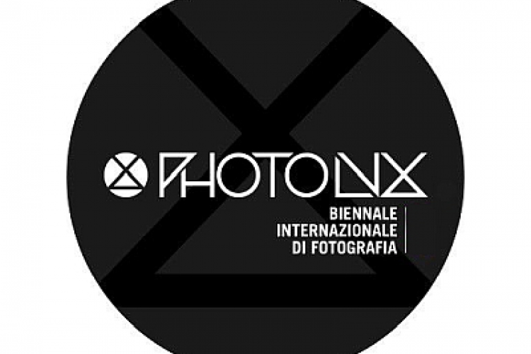 Logo nero circolare con scritte bianche e verdi di Photolux Festival